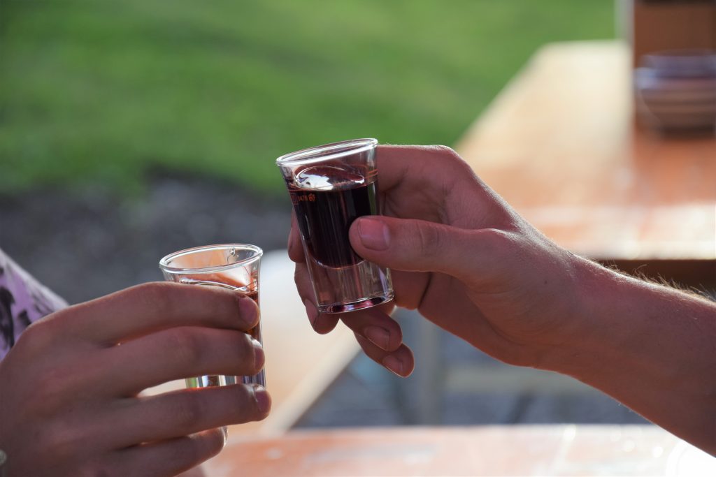 2 Personen stoßen mit hausgemachtem Schnaps an.